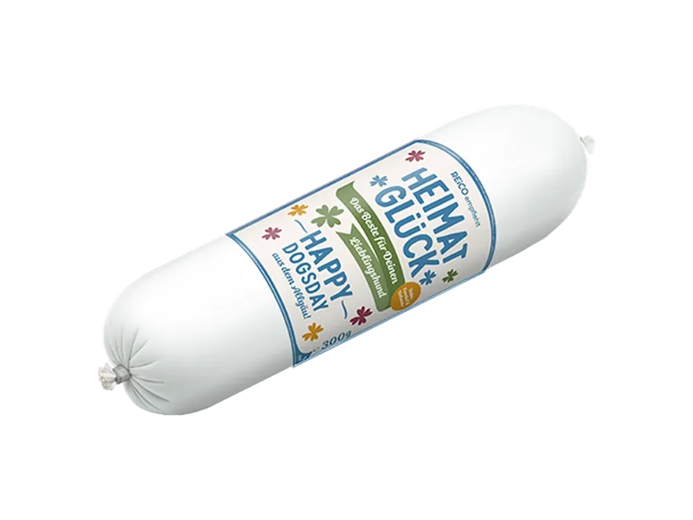 HEIMATGLÜCK Happy Dogsday, 300 g – offizielles REiCO Produktmotiv, freigestellt auf transparentem Hintergrund.